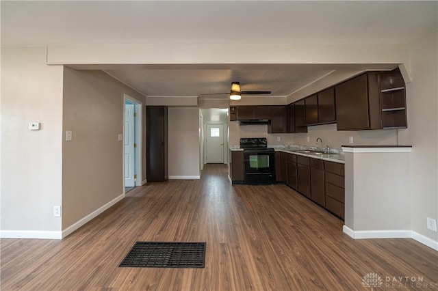 kitchen featuring dark wood-style flooring, light countertops, electric range, a sink, and dark brown cabinets