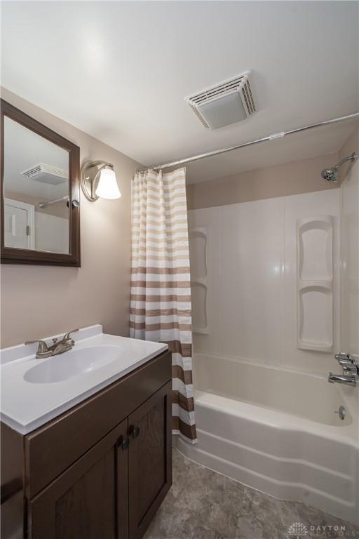 bathroom with vanity, shower / bath combo with shower curtain, and visible vents