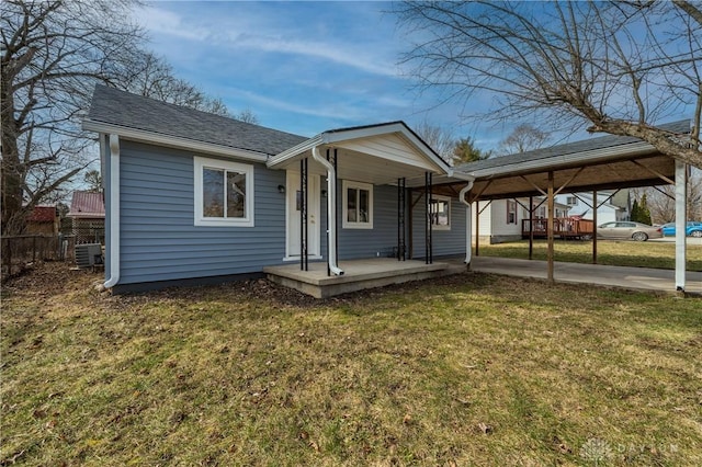 view of front of house with a carport, a front yard, a porch, and central AC unit