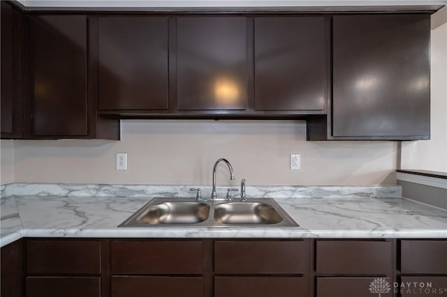 kitchen featuring dark brown cabinets and a sink