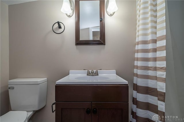 bathroom featuring toilet, a shower with shower curtain, and vanity