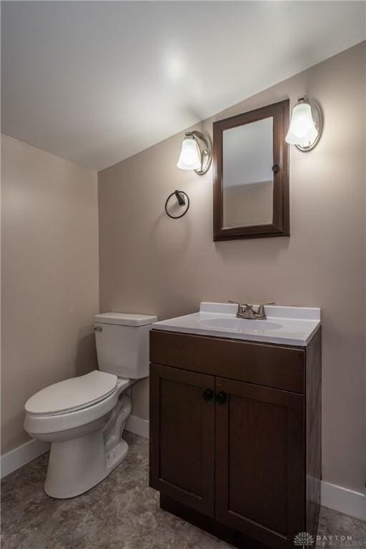 bathroom with toilet, baseboards, and vanity