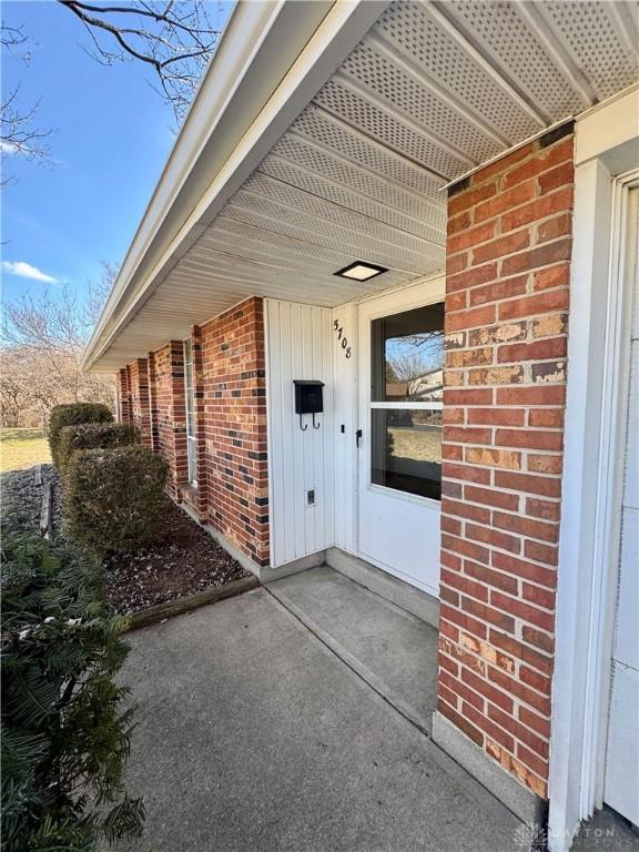 doorway to property featuring brick siding