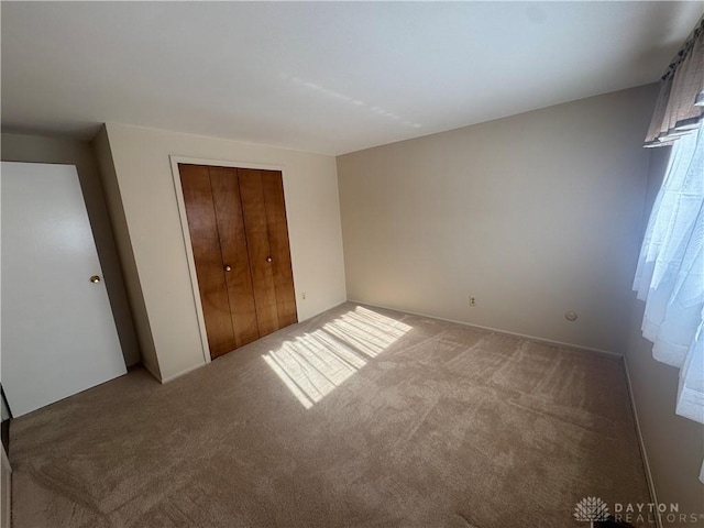 unfurnished bedroom featuring carpet floors and a closet