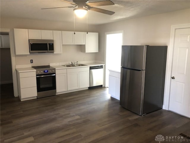 kitchen with dark wood-style flooring, ceiling fan, white cabinets, and appliances with stainless steel finishes