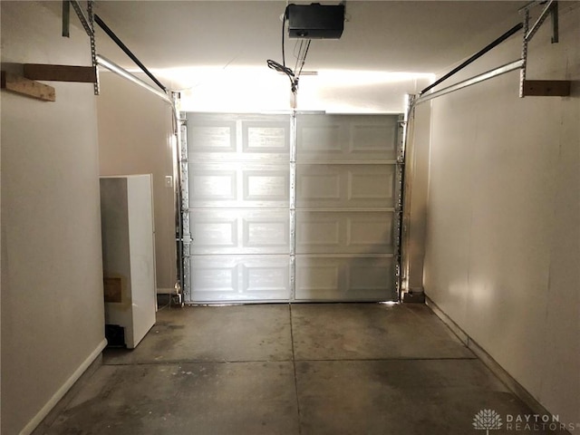garage with baseboards and a garage door opener