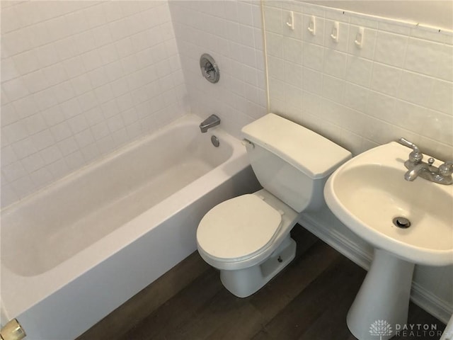 bathroom with tile walls, toilet, and wood finished floors