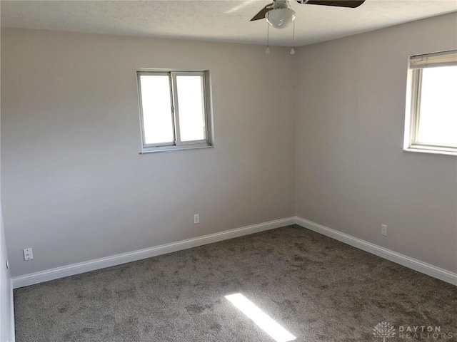 empty room with a ceiling fan, a textured ceiling, baseboards, and carpet flooring