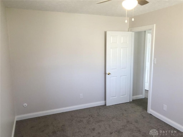 unfurnished room featuring carpet, baseboards, and a ceiling fan