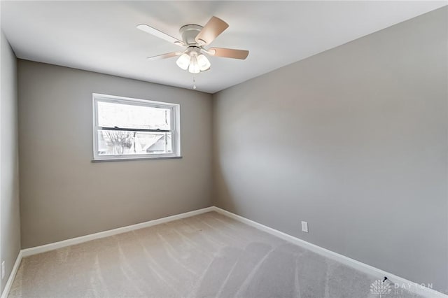 empty room featuring light colored carpet, ceiling fan, and baseboards