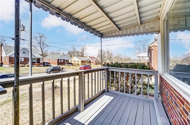 wooden terrace featuring covered porch and a residential view