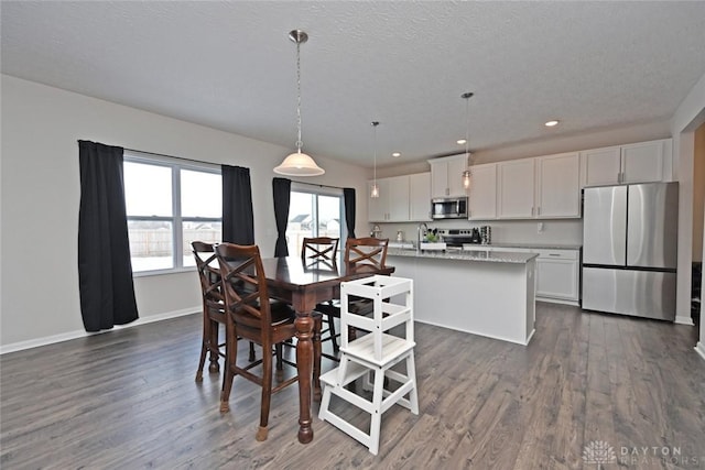 dining space with a textured ceiling, baseboards, dark wood-type flooring, and recessed lighting