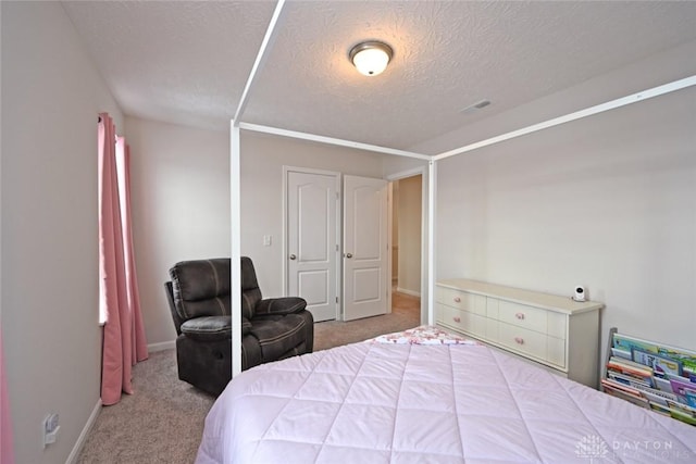 carpeted bedroom featuring baseboards and a textured ceiling