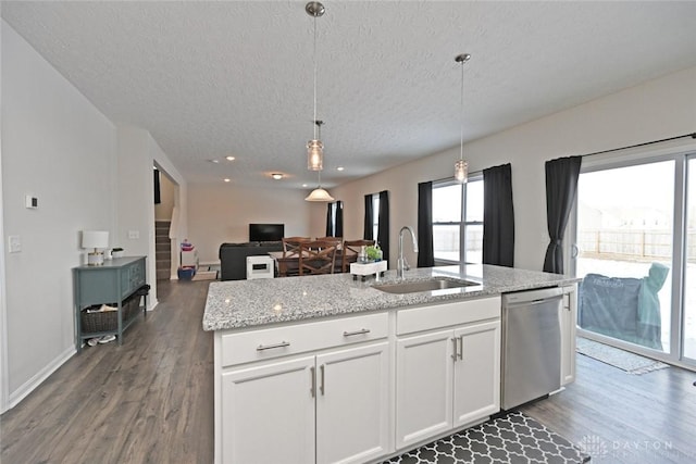 kitchen featuring pendant lighting, dark wood-type flooring, white cabinetry, a sink, and dishwasher