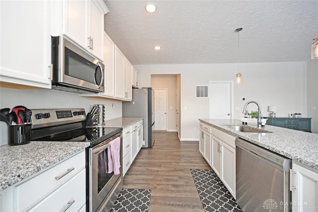 kitchen featuring appliances with stainless steel finishes, visible vents, a sink, and white cabinetry