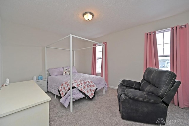 bedroom featuring baseboards, a textured ceiling, and light colored carpet