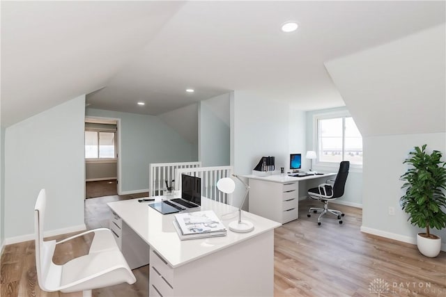 office space with vaulted ceiling, light wood-type flooring, and a wealth of natural light