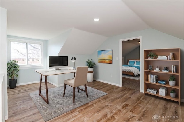 office featuring lofted ceiling, baseboards, and wood finished floors