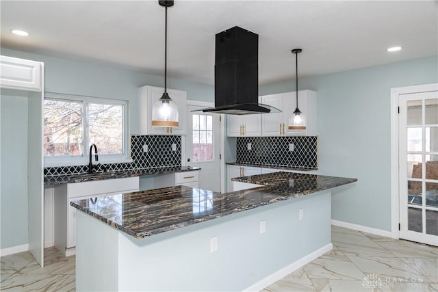 kitchen with a sink, marble finish floor, dark stone counters, and island exhaust hood