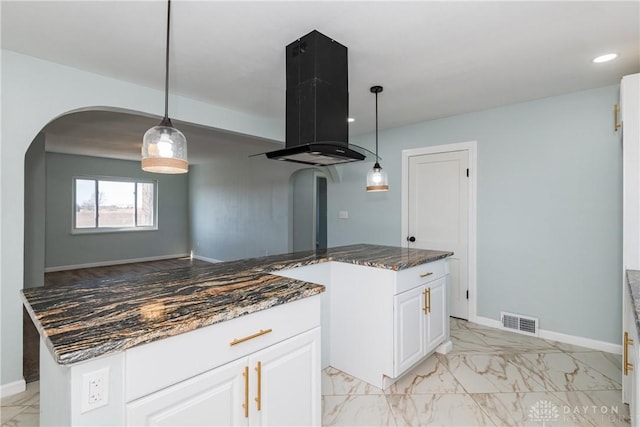 kitchen with arched walkways, marble finish floor, visible vents, and island exhaust hood