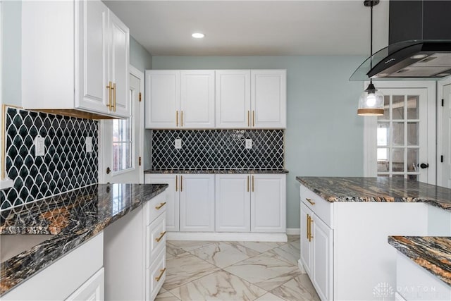 kitchen with marble finish floor, dark stone countertops, white cabinetry, and backsplash