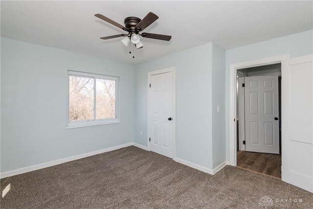 unfurnished bedroom featuring ceiling fan, dark carpet, and baseboards