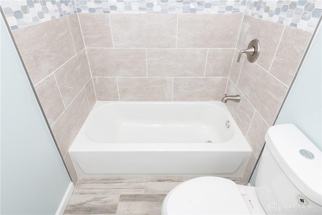 bathroom featuring a tub, a shower, and toilet