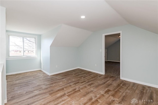 bonus room with vaulted ceiling, baseboards, and wood finished floors