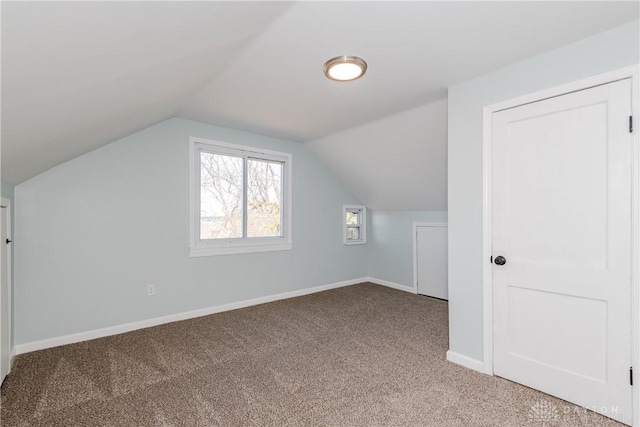 additional living space featuring carpet, vaulted ceiling, and baseboards