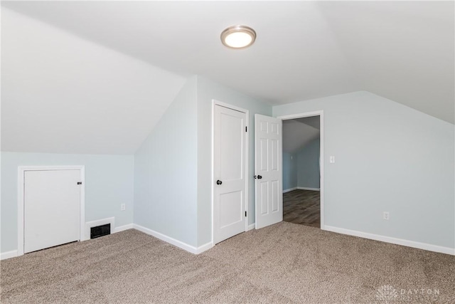 bonus room featuring lofted ceiling, carpet flooring, and visible vents