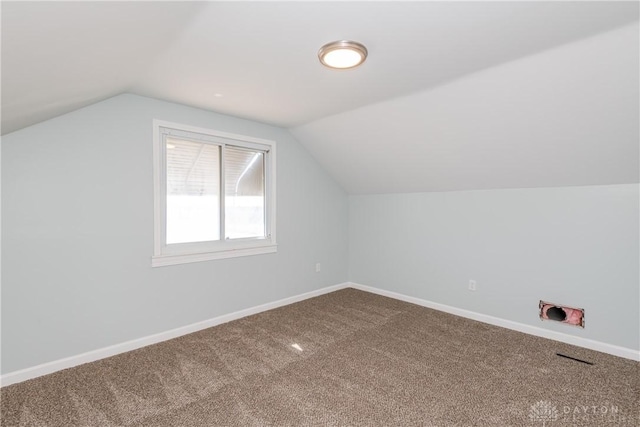 bonus room with baseboards, vaulted ceiling, and carpet flooring