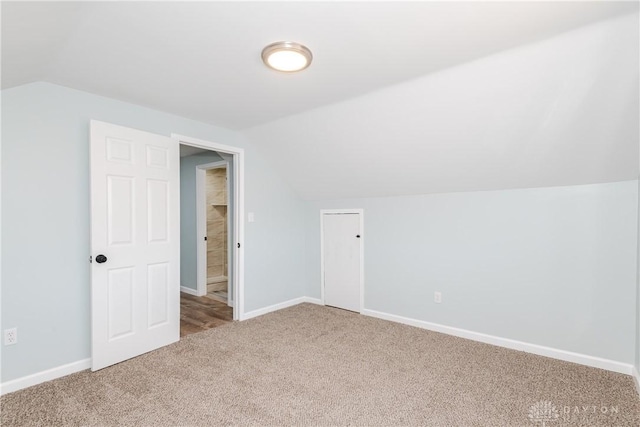 additional living space with lofted ceiling, carpet flooring, and baseboards