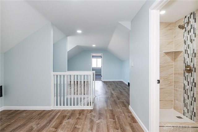 bonus room featuring baseboards, vaulted ceiling, and wood finished floors