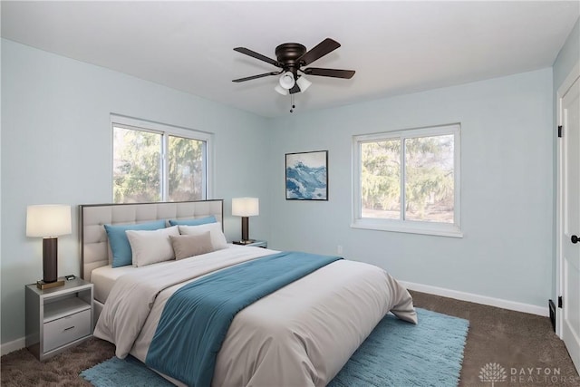 bedroom featuring baseboards, dark colored carpet, and a ceiling fan