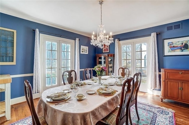 1902 N Fountain Blvd, Springfield, OH 45504 - dining room with baseboards, visible vents, wood finished floors, french doors, and a notable chandelier