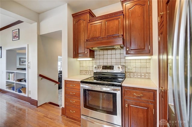 1902 N Fountain Blvd, Springfield, OH 45504 - kitchen featuring decorative backsplash, light wood-style flooring, custom exhaust hood, stainless steel appliances, and light countertops
