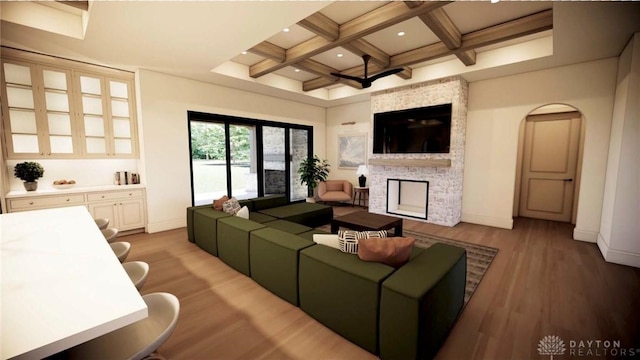 living room featuring beam ceiling, a fireplace, light wood finished floors, coffered ceiling, and baseboards