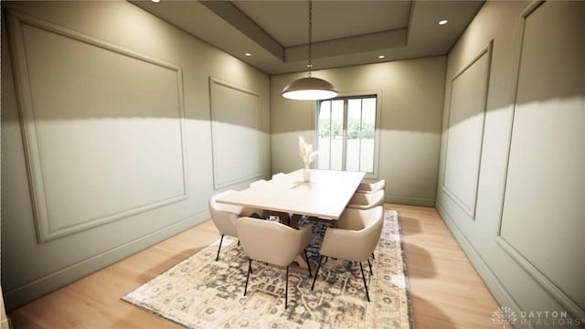 dining room with recessed lighting, a raised ceiling, and light wood-style flooring