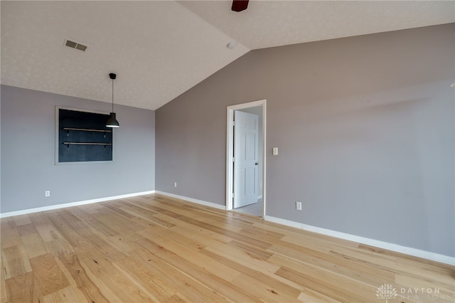 unfurnished room featuring lofted ceiling, light wood-style flooring, visible vents, and baseboards