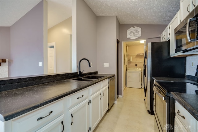 kitchen featuring a sink, white cabinetry, appliances with stainless steel finishes, dark countertops, and washer / dryer