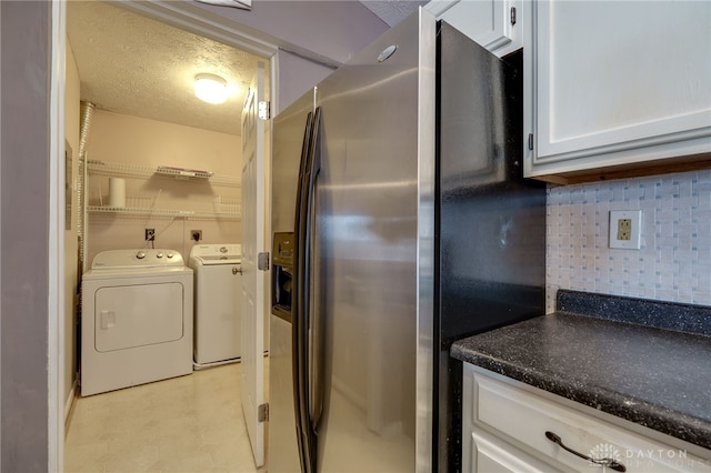 interior space featuring stainless steel fridge, decorative backsplash, a textured ceiling, light floors, and separate washer and dryer