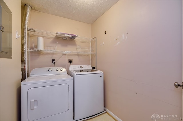 clothes washing area featuring washing machine and dryer, laundry area, electric panel, and a textured ceiling