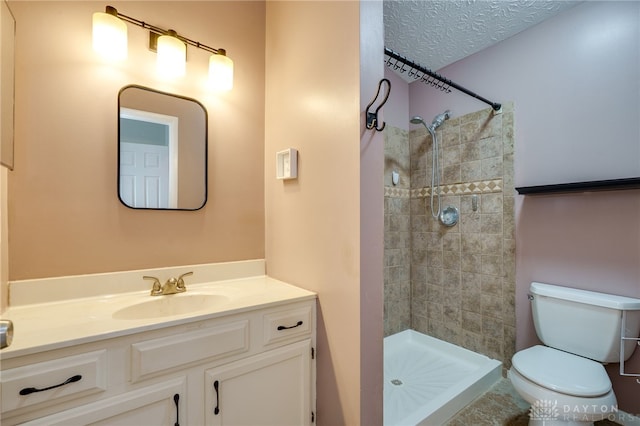 bathroom featuring a textured ceiling, vanity, a shower stall, and toilet