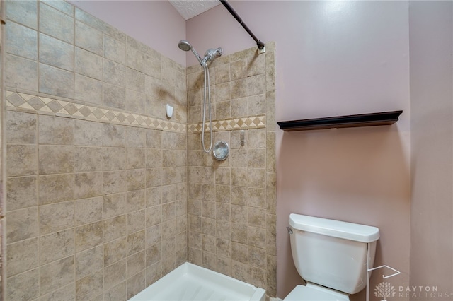 bathroom with tiled shower and toilet