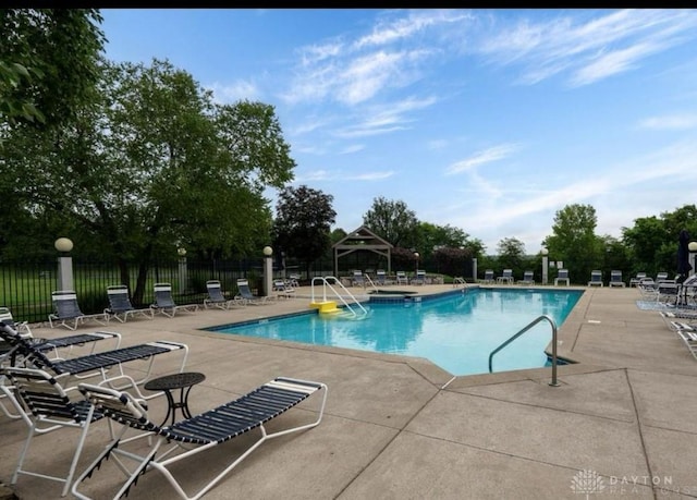 community pool featuring a patio, a gazebo, and fence