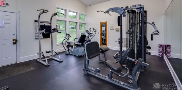 gym with baseboards and vaulted ceiling