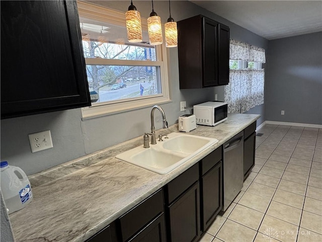 kitchen with decorative light fixtures, light tile patterned floors, white microwave, a sink, and dishwasher