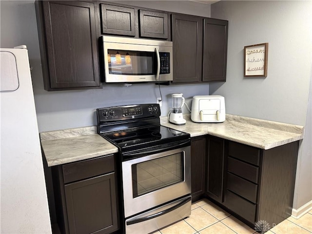 kitchen featuring light tile patterned floors, light countertops, appliances with stainless steel finishes, and dark brown cabinetry