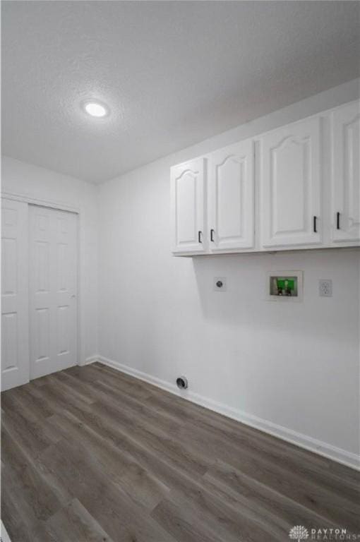 laundry area with electric dryer hookup, a textured ceiling, dark wood finished floors, cabinet space, and hookup for a washing machine