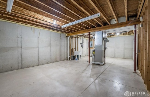 unfinished basement with heating unit and a sink